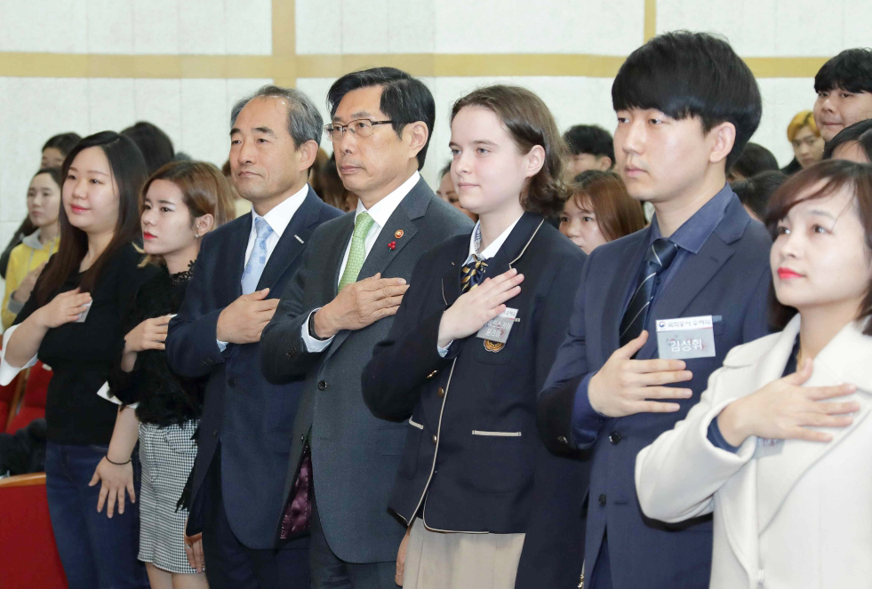 박상기 법무부 장관(가운데)이 21일 서울 용산구 국립한글박물관 대강당에서 열린 제1회 대한민국 국적증서 수여식에서 국기에 대한 경례를 하고 있다.[사진제공=법무부]